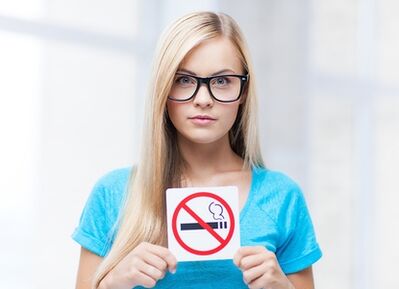 Κορίτσι που κρατά πινακίδα απαγόρευσης καπνίσματος στην είσοδο